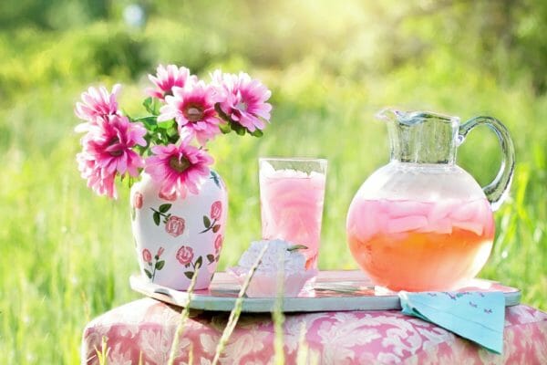 Flowers and iced drink on table.